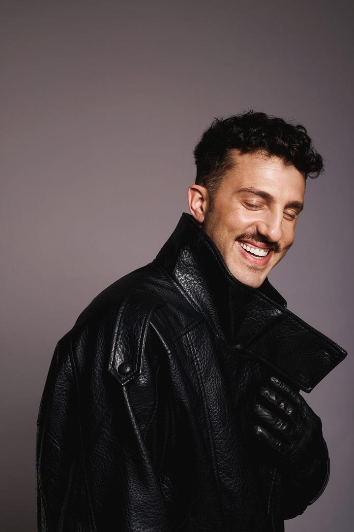 Tomer Tenenboym smiling in a black leather coat